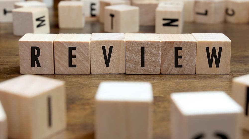 Wooden blocks spelling our Review - in a Property Market Report